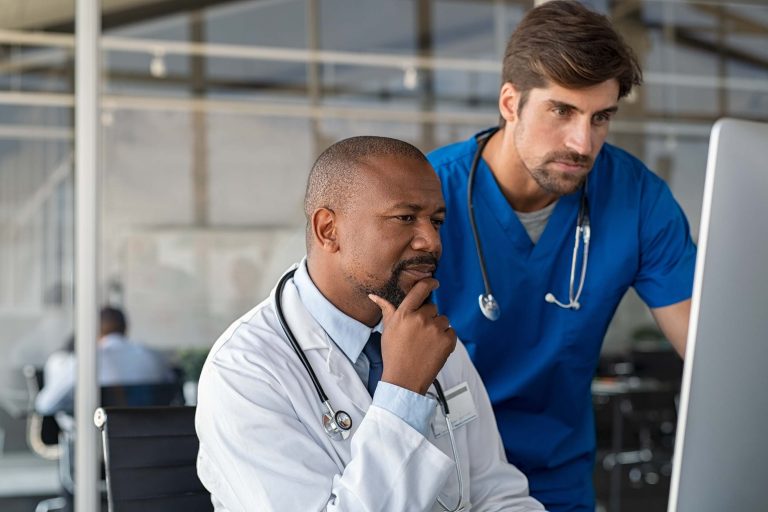 Healthcare providers consulting at computer monitor